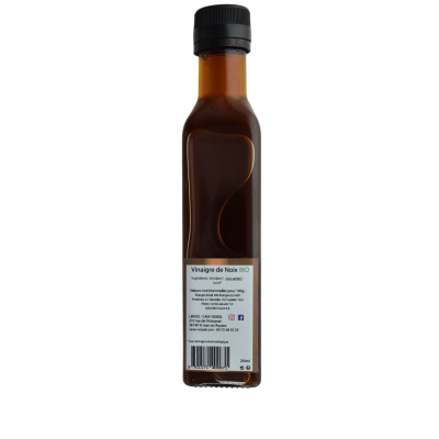Bouteille de vinaigre de noix de Cave Noisel en verre sur sa face verso avec son étiquette d'ingrédients